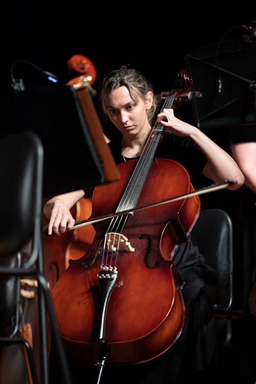 Woman Sitting on Black Chair Playing Cello