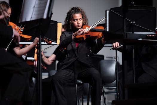 Black woman violinist performing at a concert, focused on her music.