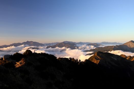 Breathtaking view of mountain peaks above clouds at sunset in Taiwan’s scenic Taoyuan District.