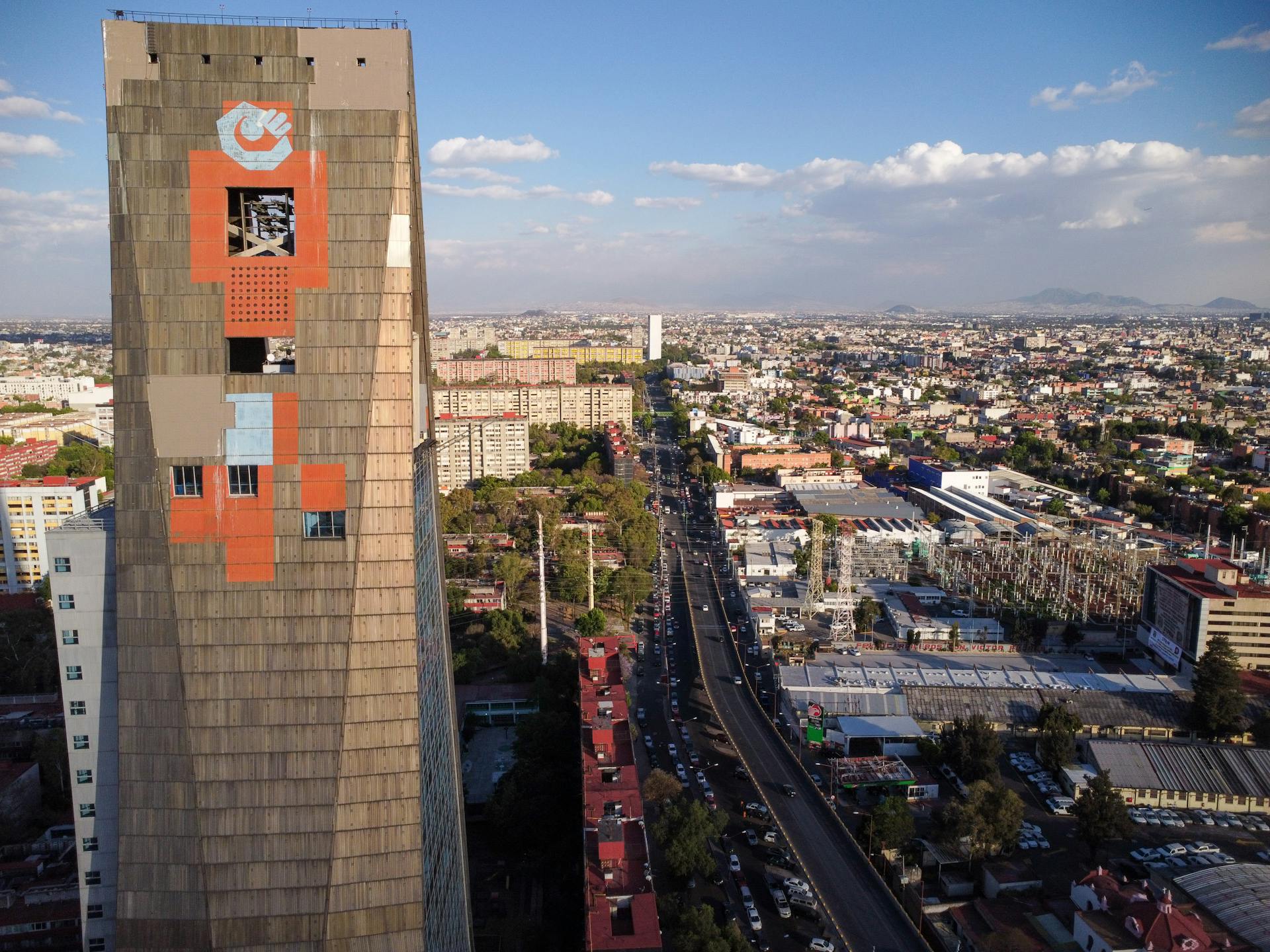 Aerial view of Torre de Tlatelolco and bustling Mexico City during the day.