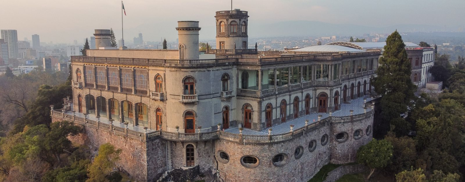 Stunning aerial view of Chapultepec Castle perched on a hill in Mexico City at sunset.