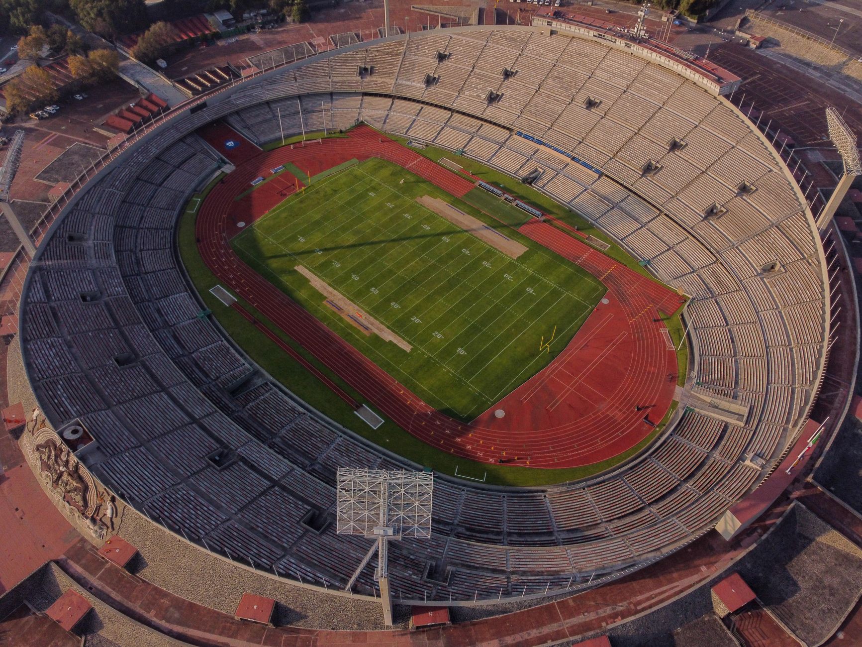 High-angle aerial view of an empty stadium with a field and track, showcasing its architectural design.