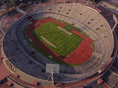 High-angle aerial view of an empty stadium with a field and track, showcasing its architectural design.