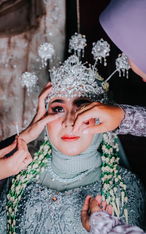 Hands around Bride in Crown and Traditional Clothing