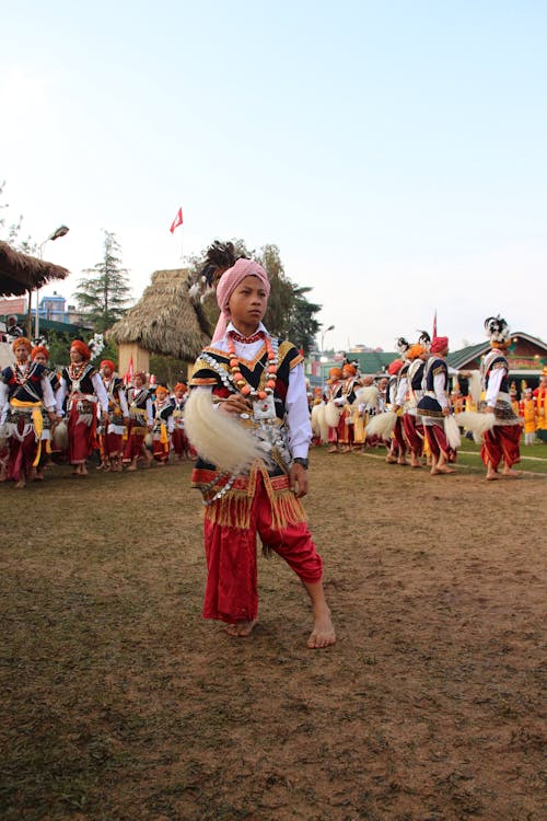 A Boy Wearing Traditional Wear in a Parade