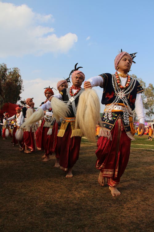 Dancers in Costumes on Grassland