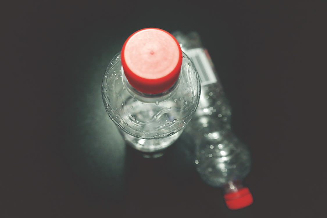 Dos Botellas De Plástico Transparente Sobre Superficie Negra