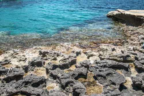 Free Explore the rugged rocky seashore with vivid turquoise water providing a stunning coastal view. Stock Photo