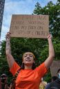 A Woman Holding a Protest Poster