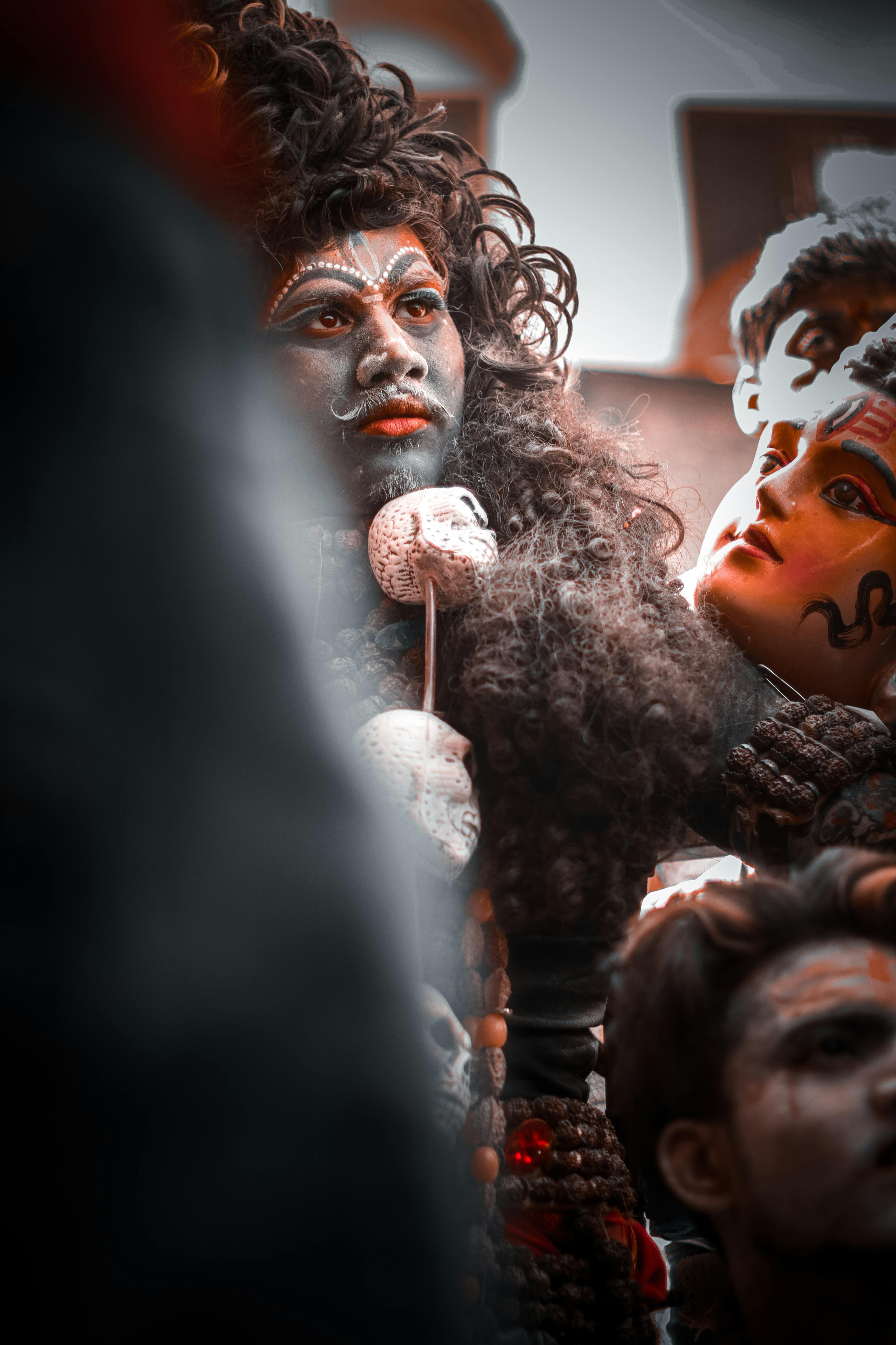 Free Man with Face Paint beside a Statue Stock Photo