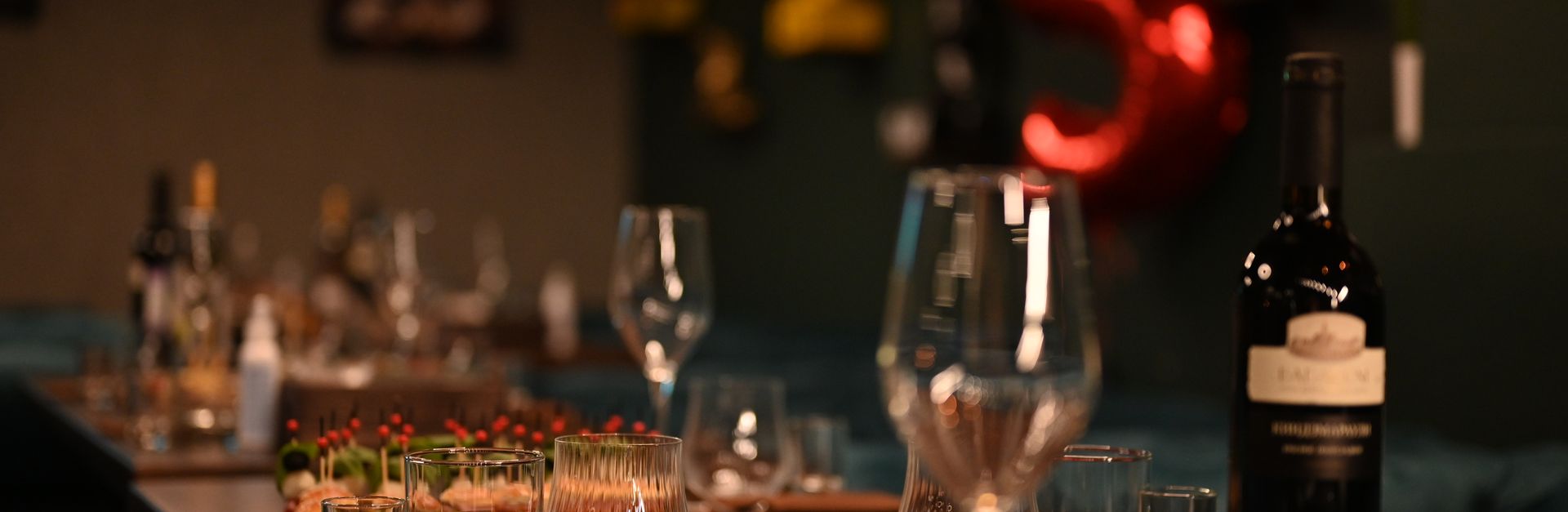 An indoor table setup featuring wine bottles and glassware, creating an elegant ambiance for a dinne