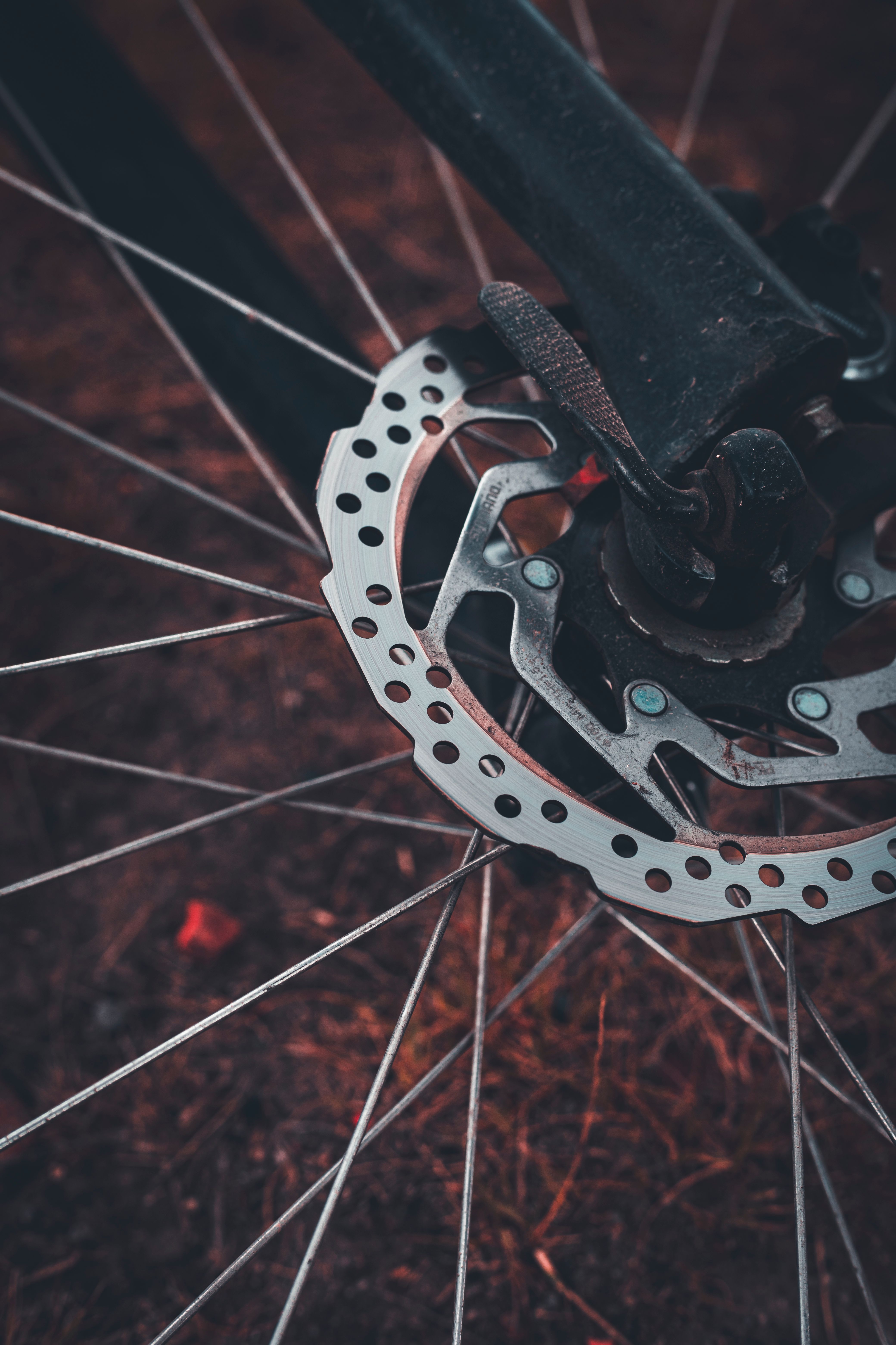 Detailed view of a bicycle's disc brake and wheel showcasing metallic texture and design.
