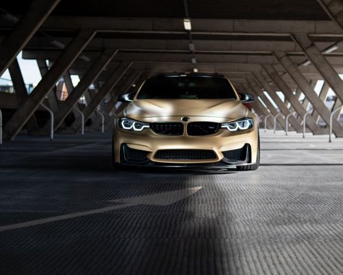 Free Front view of a luxury BMW coupe parked in an urban setting under a parking structure. Stock Photo