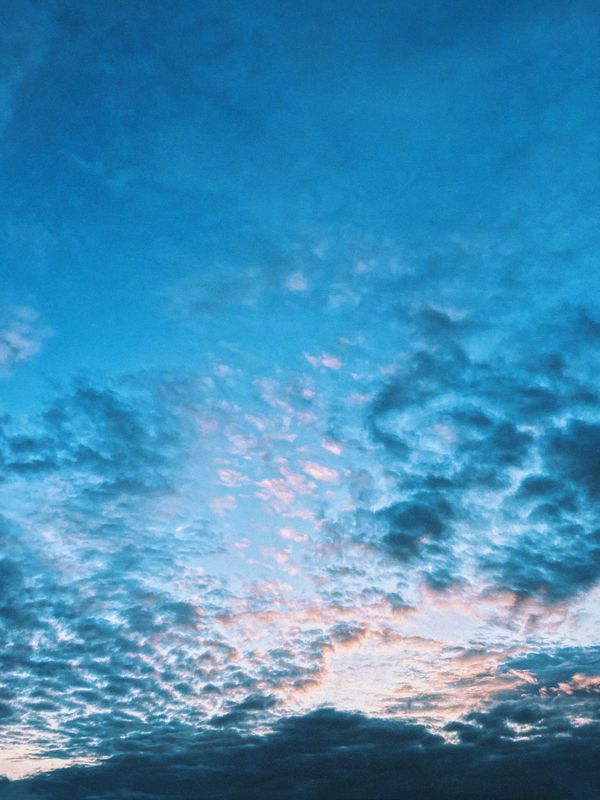 Um céu deslumbrante repleto de nuvens azuis e rosas durante o crepúsculo.