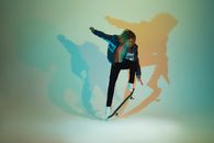 Woman in Blue Jacket and Black Pants Standing on White and Blue Surfboard