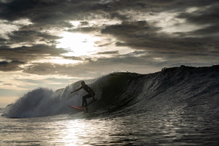 Person Surfing On Sea Wave