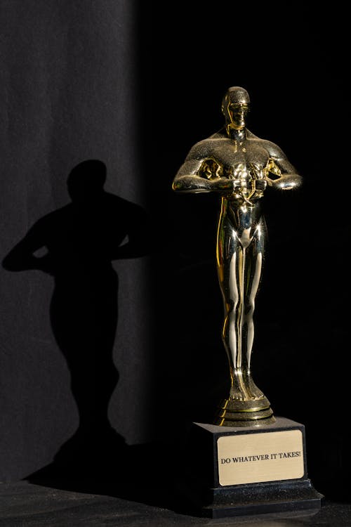Oscar Decorativo Em Destaque Lançando Uma Sombra No Fundo Preto