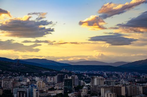 Free A beautiful aerial view of a cityscape at sunset, highlighting the vibrant sky and urban skyline below. Stock Photo