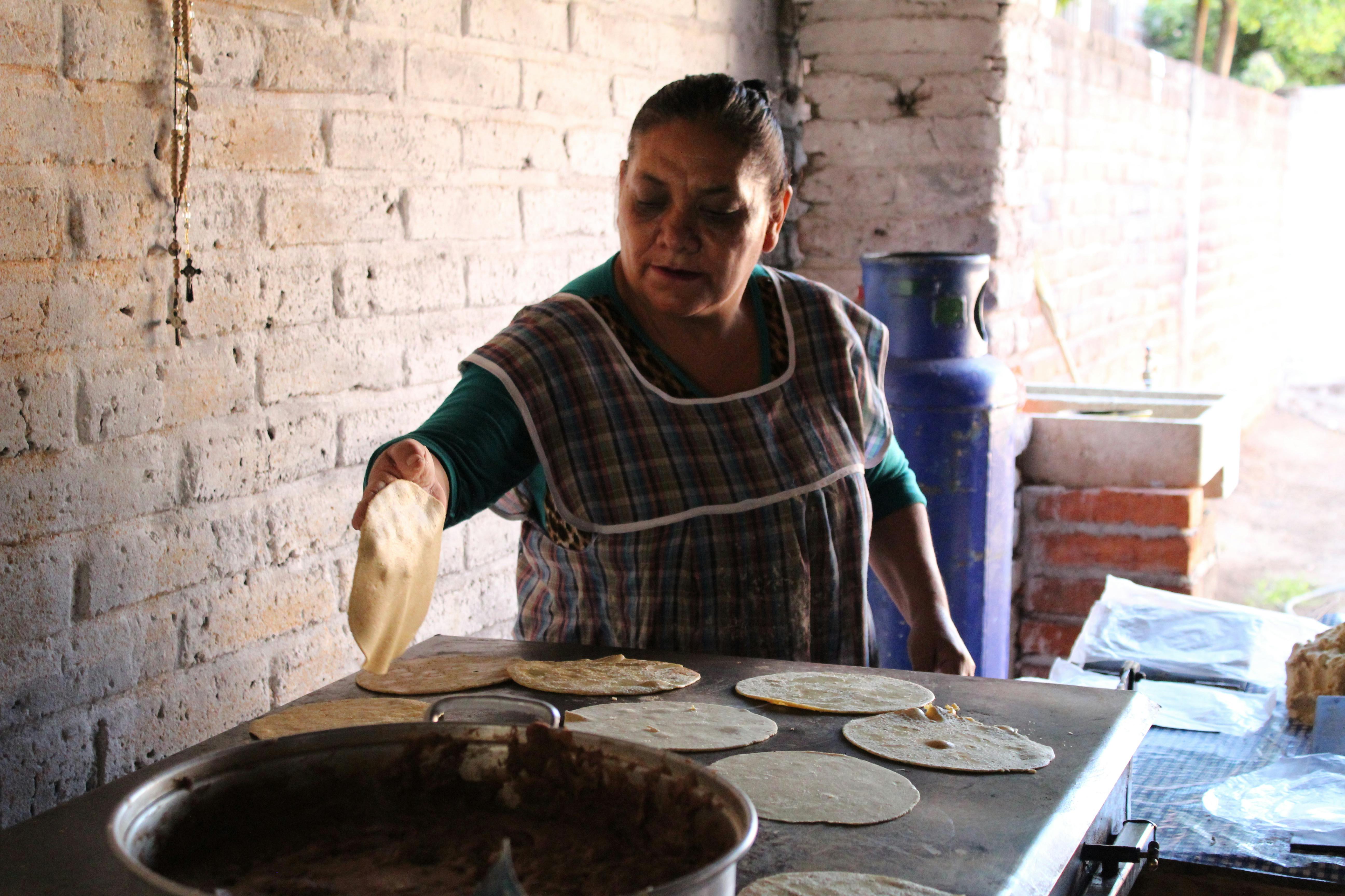 Female cook placing handmade tortillas on a big comal Stock Video Footage  by ©KanelBulle #456050806