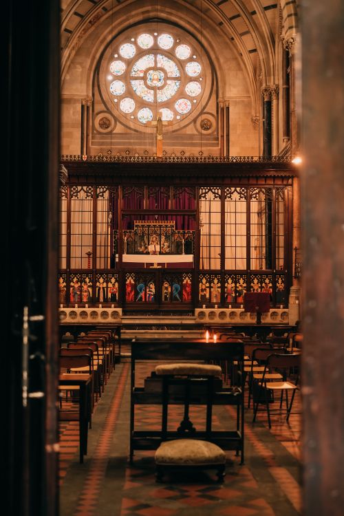 Free Beautiful interior view of a Gothic-style church altar with stained glass window. Stock Photo