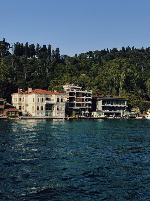 Free Picturesque waterfront houses along a serene river with lush greenery in the backdrop. Stock Photo