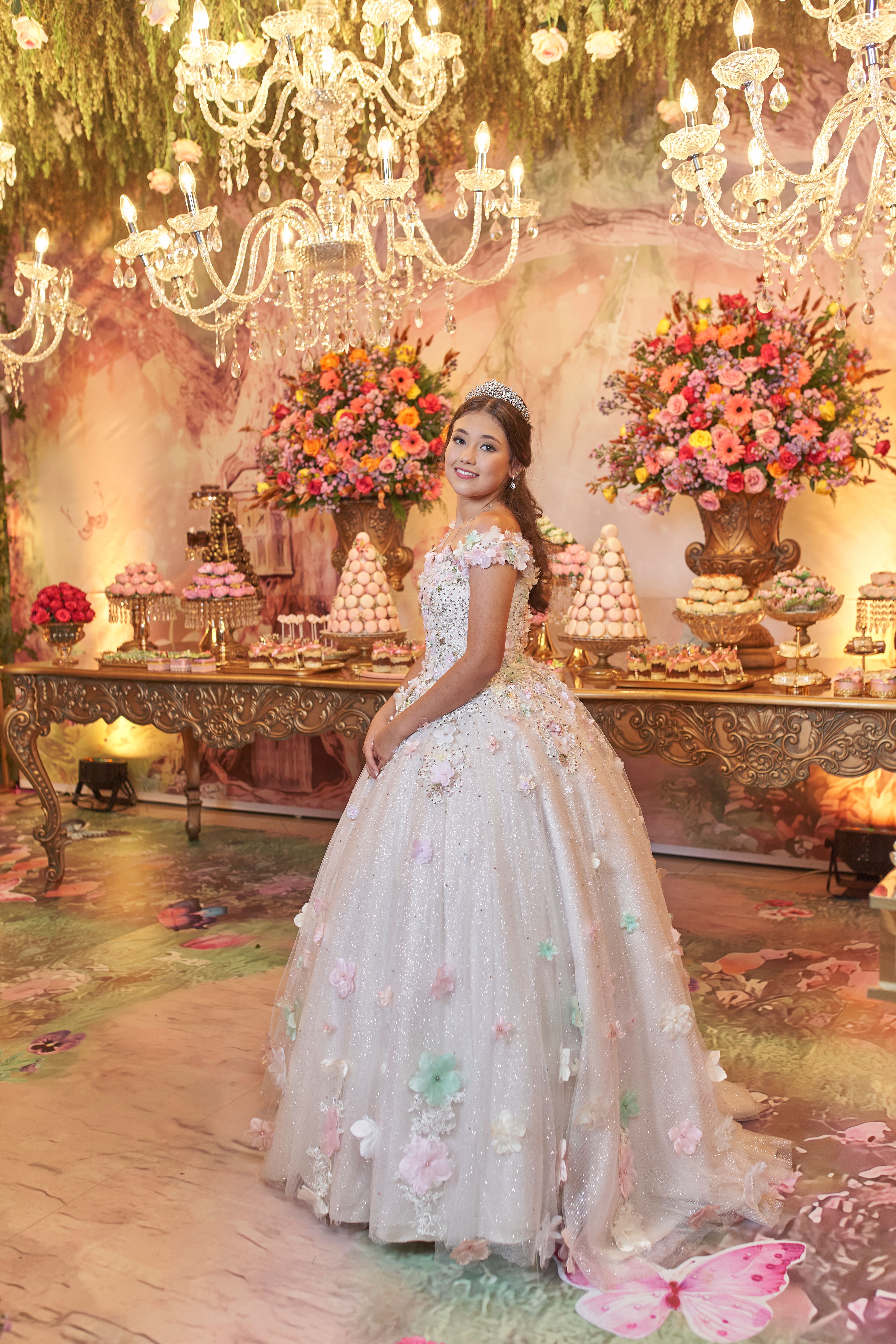 A quinceañera celebration featuring a teenage girl in an elegant white dress with elaborate decorations.