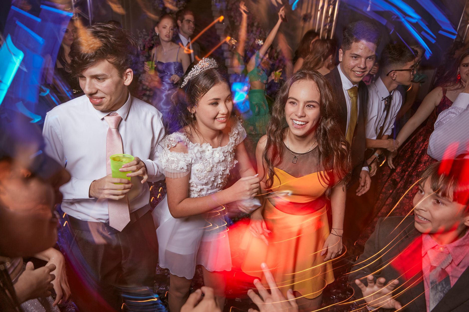 Prom Stage Announcement Checklist for DJs and School Staff Energetic group of teenagers enjoying a lively party with lights and music.