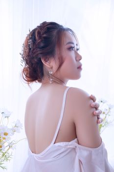 A serene portrait of a woman gazing away, surrounded by delicate blooms.