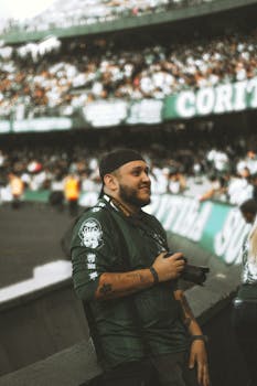 Photographer with camera enjoying a lively soccer match in Curitiba, Brazil.
