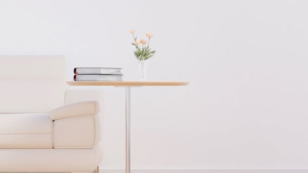 Stylish living room featuring a beige sofa, wooden table, and fresh flowers in a vase.