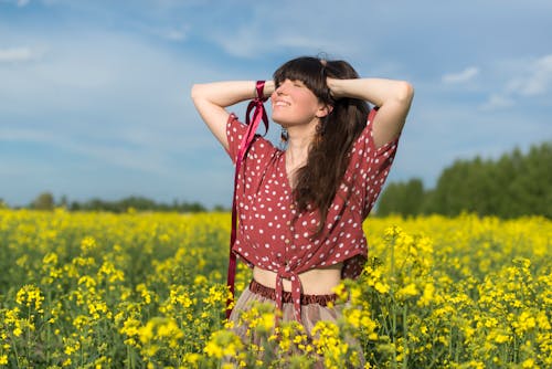 Free A Woman Standing on Canola Field Stock Photo