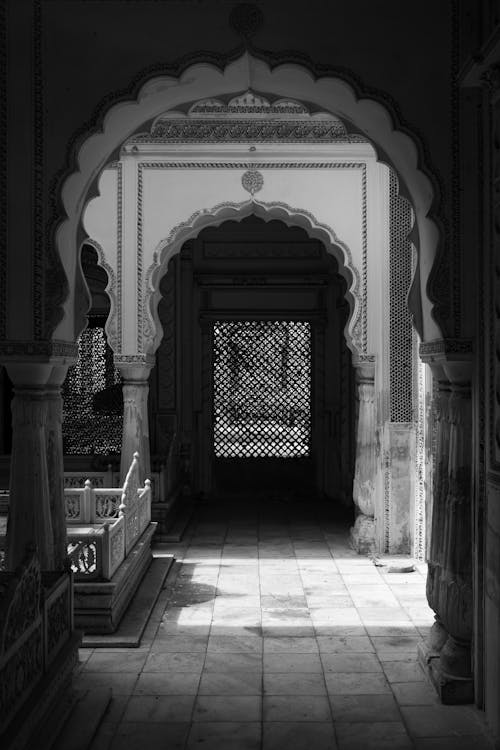 Grayscale Photo of an Old Arched Hallway Inside a House