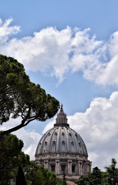 Low angle view of St. Peter's Basilica dome against a blue sky in Vatican City.