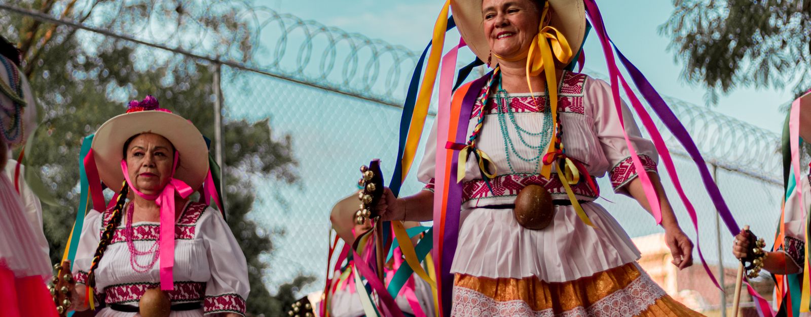Vibrant display of Mexican heritage with women in colorful traditional costumes at a festival.