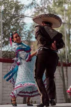Vibrant scene of traditional Mexican folk dancers in colorful attire performing outdoors.