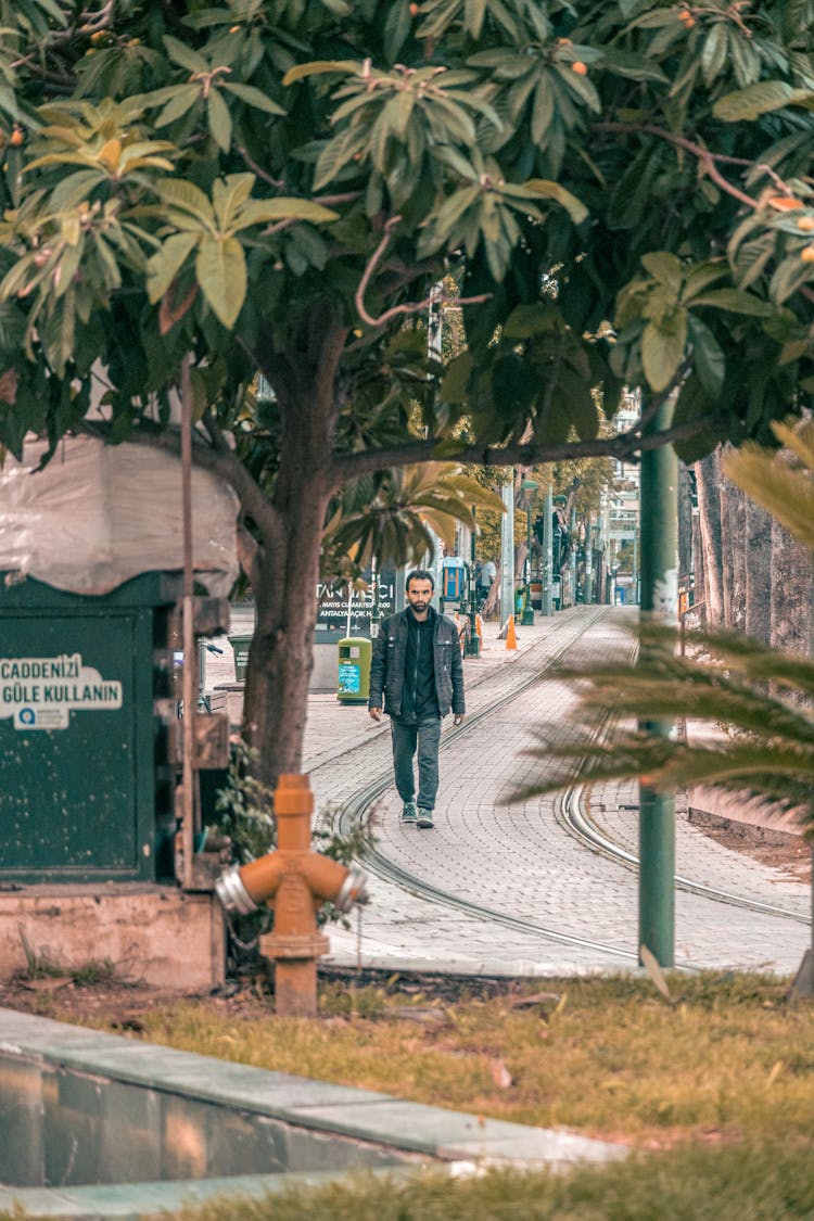 Man Walking On Tramway Tracks In City