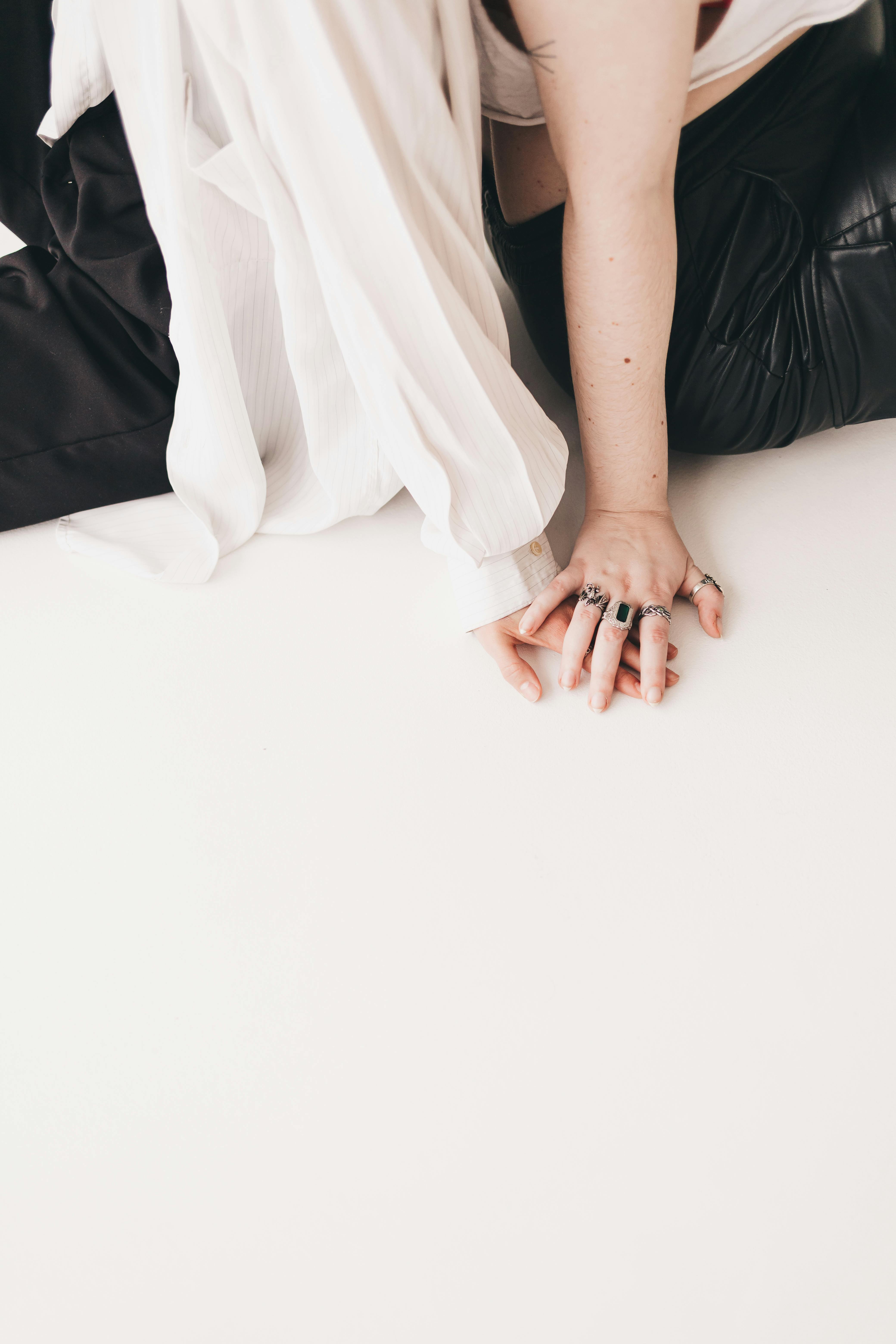 Creative close-up of intertwined hands on a white floor. Perfect for conceptual themes.