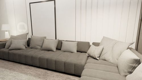 Free Elegant modern living room featuring a large gray sofa and minimalist decor for a cozy ambiance. Stock Photo