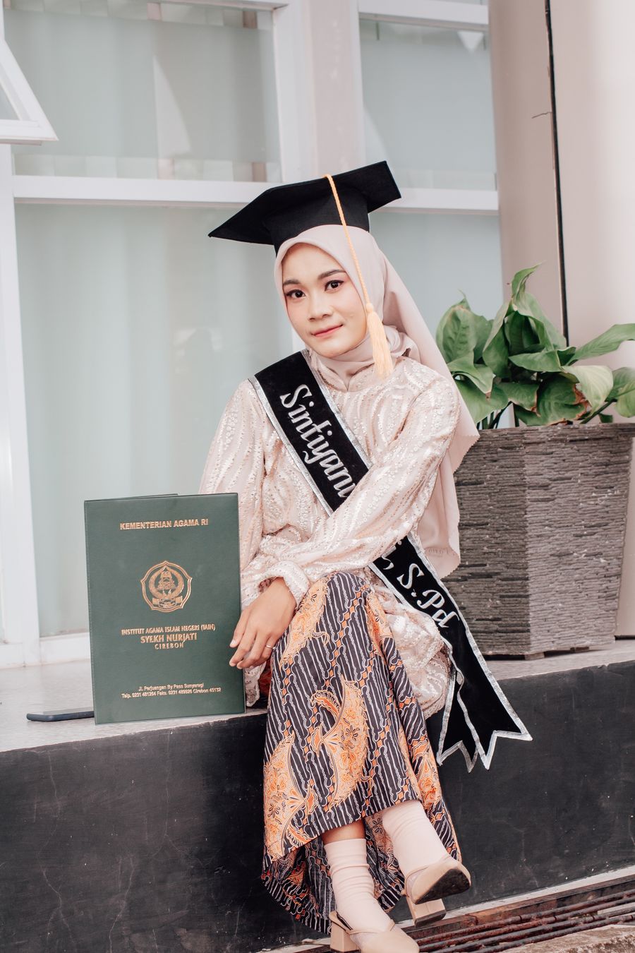 Wisudawati berhijab memegang ijazah kelulusan