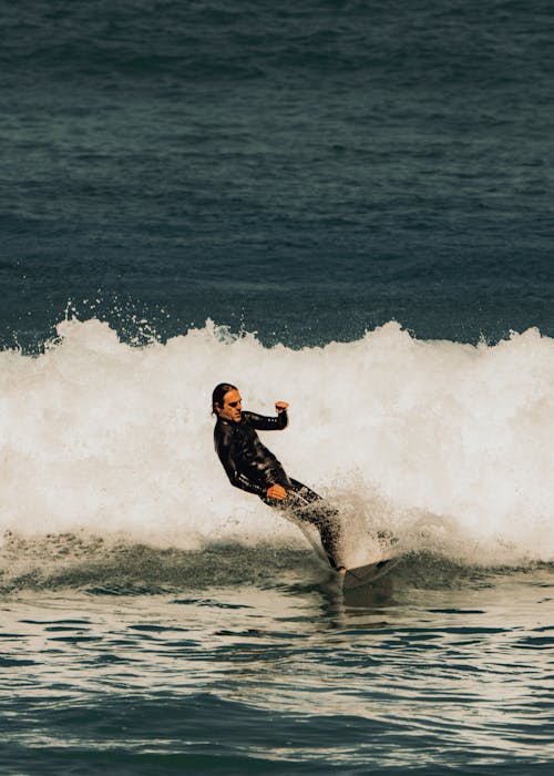 Man in Wetsuit Riding the Waves