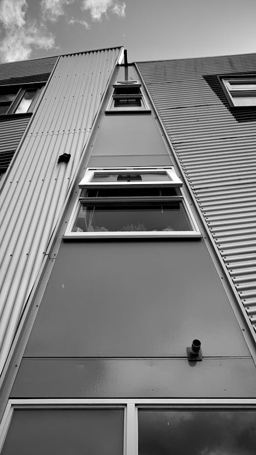 Grayscale Photo of Glass Windows on a Building