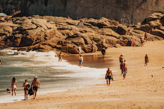 A vibrant beach scene at Riazor Beach, Galicia, with people enjoying a sunny day by the shore.