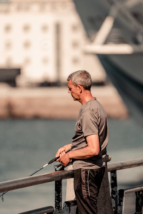 A Man in Gray Shirt Holding Fishing Rod