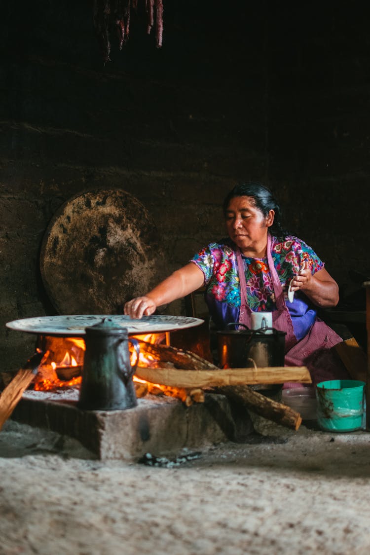 Woman Cooking By Fireplace