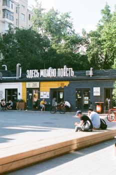Vibrant urban street scene with people relaxing and buildings in the background.