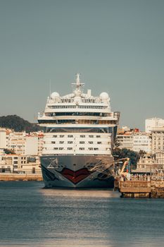 A stunning view of a cruise ship docked at La Coruña harbor, Spain, in a serene setting.