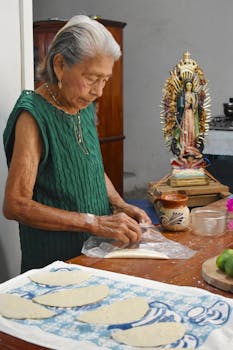 An elderly woman prepares empanadas in a cozy kitchen in Veracruz, Mexico.