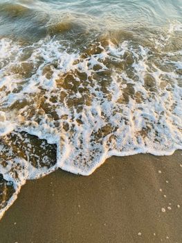 Soothing ocean waves gently crash onto a sandy beach, capturing the essence of calm relaxation.