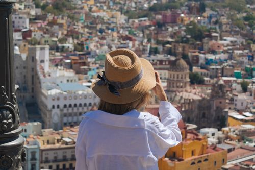 Free A woman in a hat enjoys the vibrant city view of Guanajuato, Mexico. Stock Photo