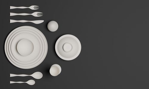 Free Top view of elegant white tableware with spoons and forks on a dark surface. Stock Photo